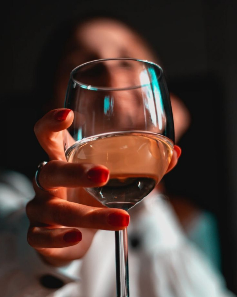 Gast die proost met een glas wijn tijdens de High Wine bij NJOY Kampen