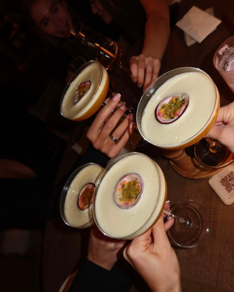 Groep gasten proost met Frozen Pornstar cocktails bij NJOY Kampen